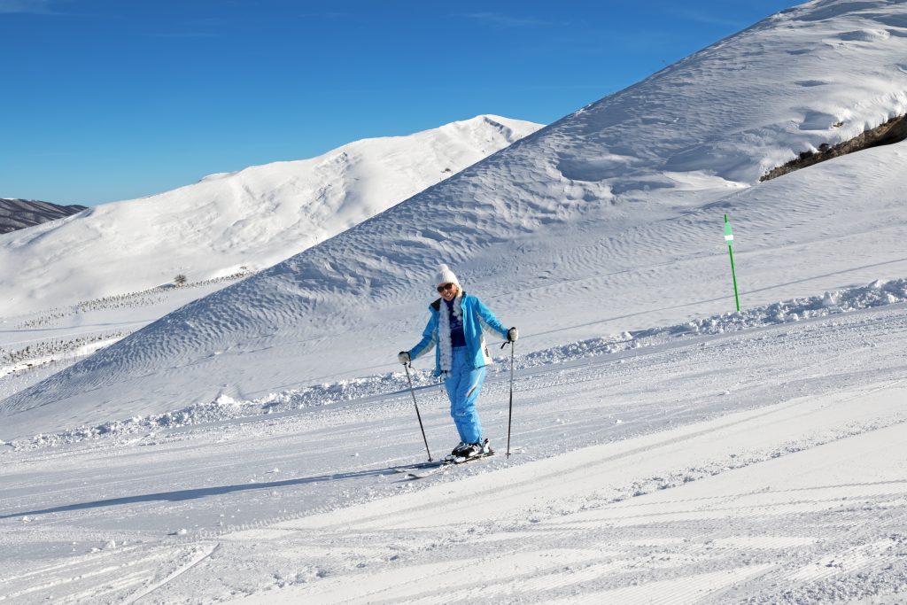 Skier on snowy sunlight ski slope at nice sun day. Greater Caucasus in winter, Shahdagh, Azerbaijan.